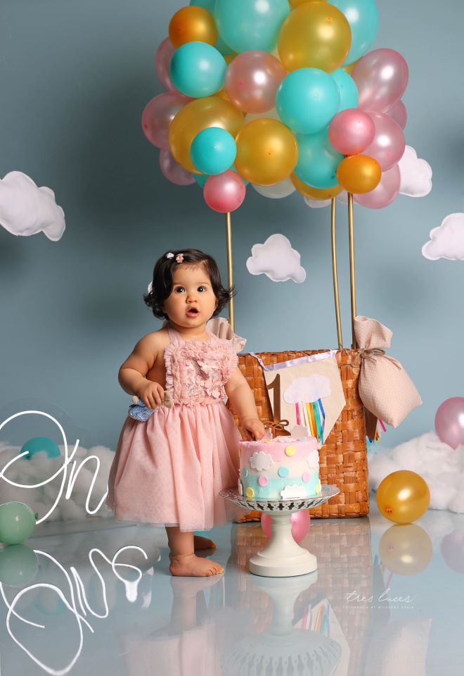 Niña con un pastel de cumpleaños, sesión de fotos de bebé de 1 año